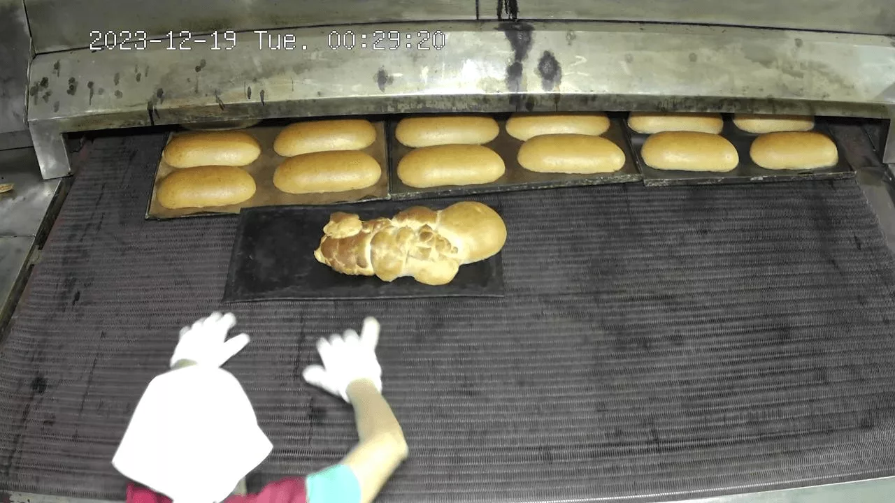 Deformed bakery product with shape defects on the conveyor belt — a defect during the transition to a new variety, detected by computer vision in the production quality control system