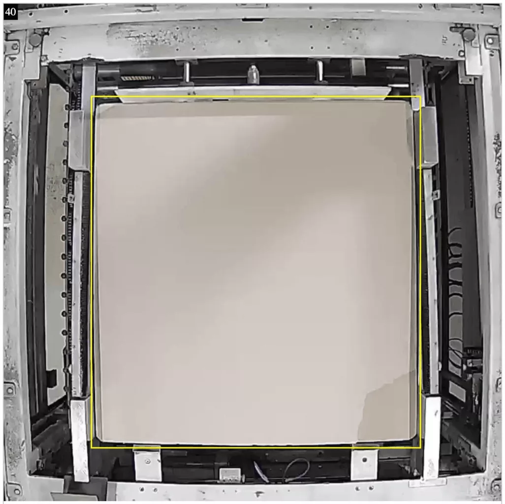 A torn edge of packaging cardboard on a pallet with aluminium cans — a defect detected by computer vision during quality control