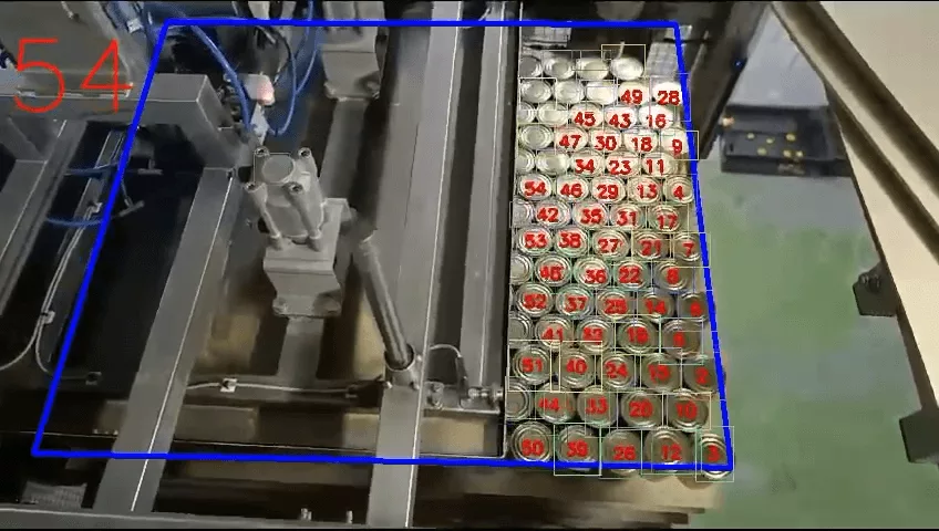 Test video frame with a blue counting zone for identifying cans on a magnetic plate.